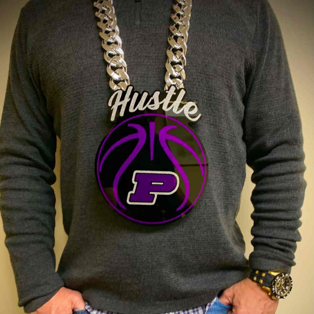 Hustle script pendant over a purple basketball and letter P.