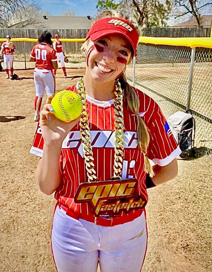 Softball player holding a ball while wearing an Epic chain.