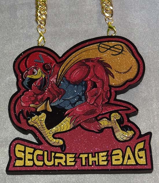 Secure The Bag bird mascot pendant on a gold chain.